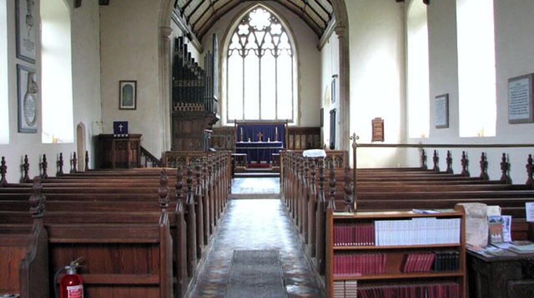 All Saints church in Alburgh - view east. The tower of All Saints church > 1770481 is very tall and can be seen for miles. It is believed that the church stands on an older place of worship. The bottom section, built in the 15th century from flints found in the surrounding fields, is contemporary with the rest of the building. The church was extensively restored and partially rebuilt in the 19th century but the C15 rood screen dado > 1770503 has survived. Everything else dates from the Victorian restoration as do the stained glass windows > 1770510.