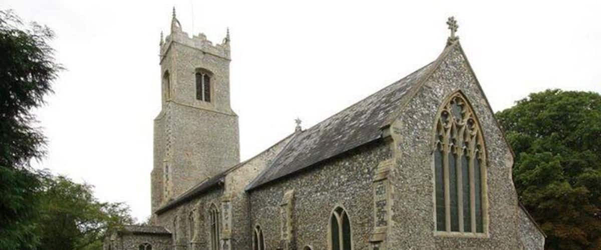 An old stone church with a bell tower and a graveyard.