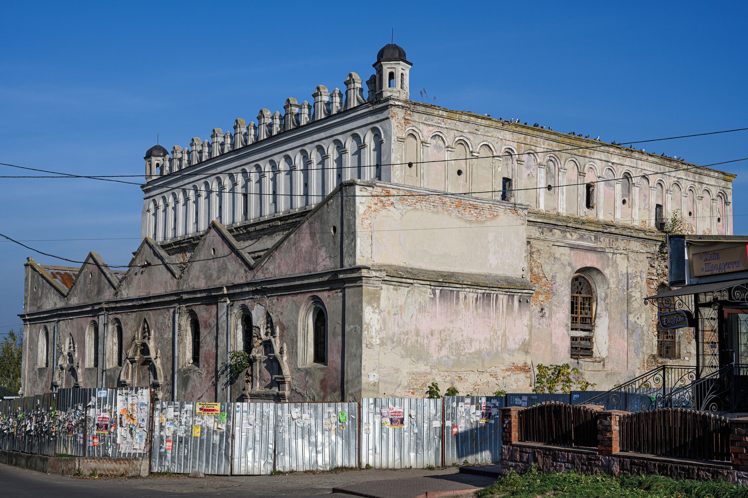 An old, weathered building with arched windows and a bell tower.