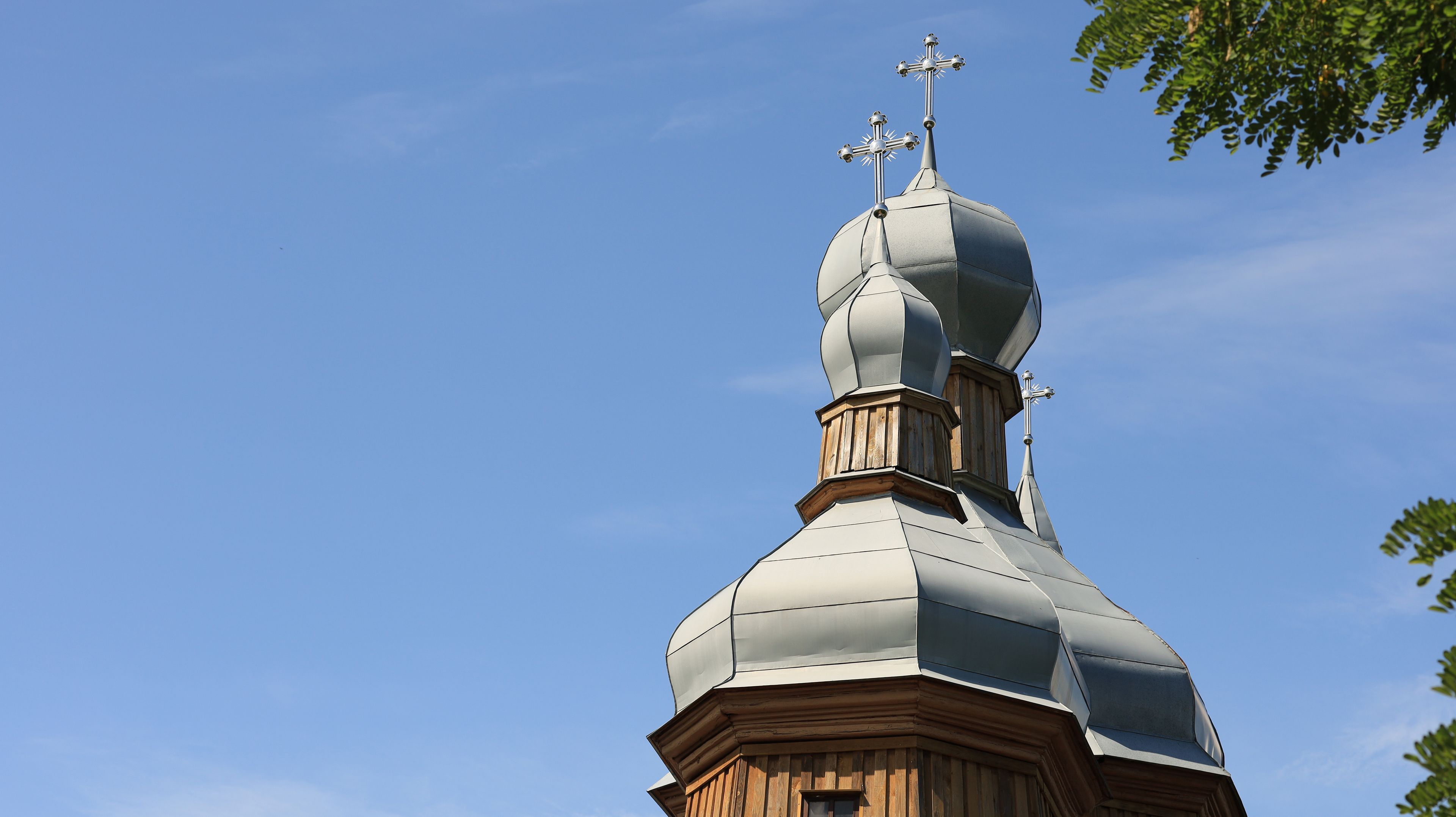 Un clocher d’église surmonté d’une croix et d’une girouette.