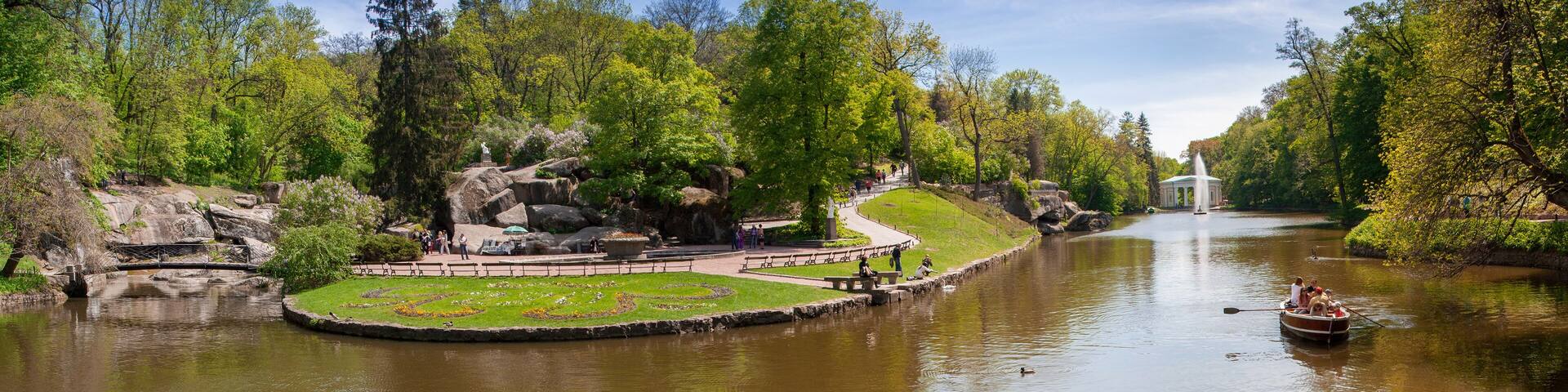 A park with a pond, a gazebo, and a statue.