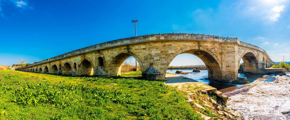 A stone bridge with multiple arches over a river.