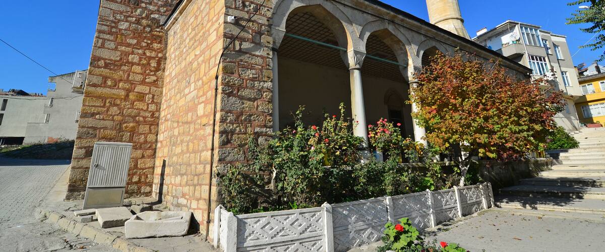 A historic building with a stone facade, arched windows, and a tall minaret.
