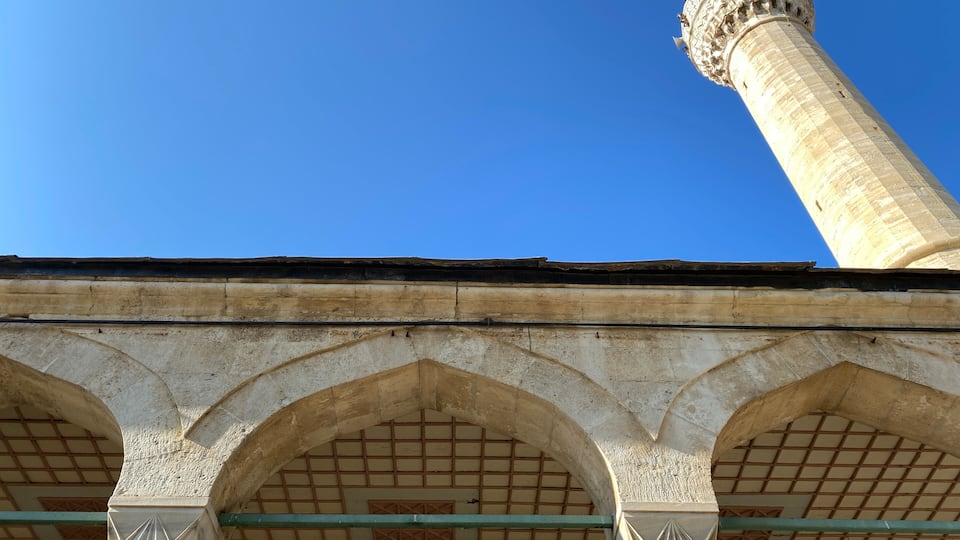 A mosque with a tall minaret and arched windows.