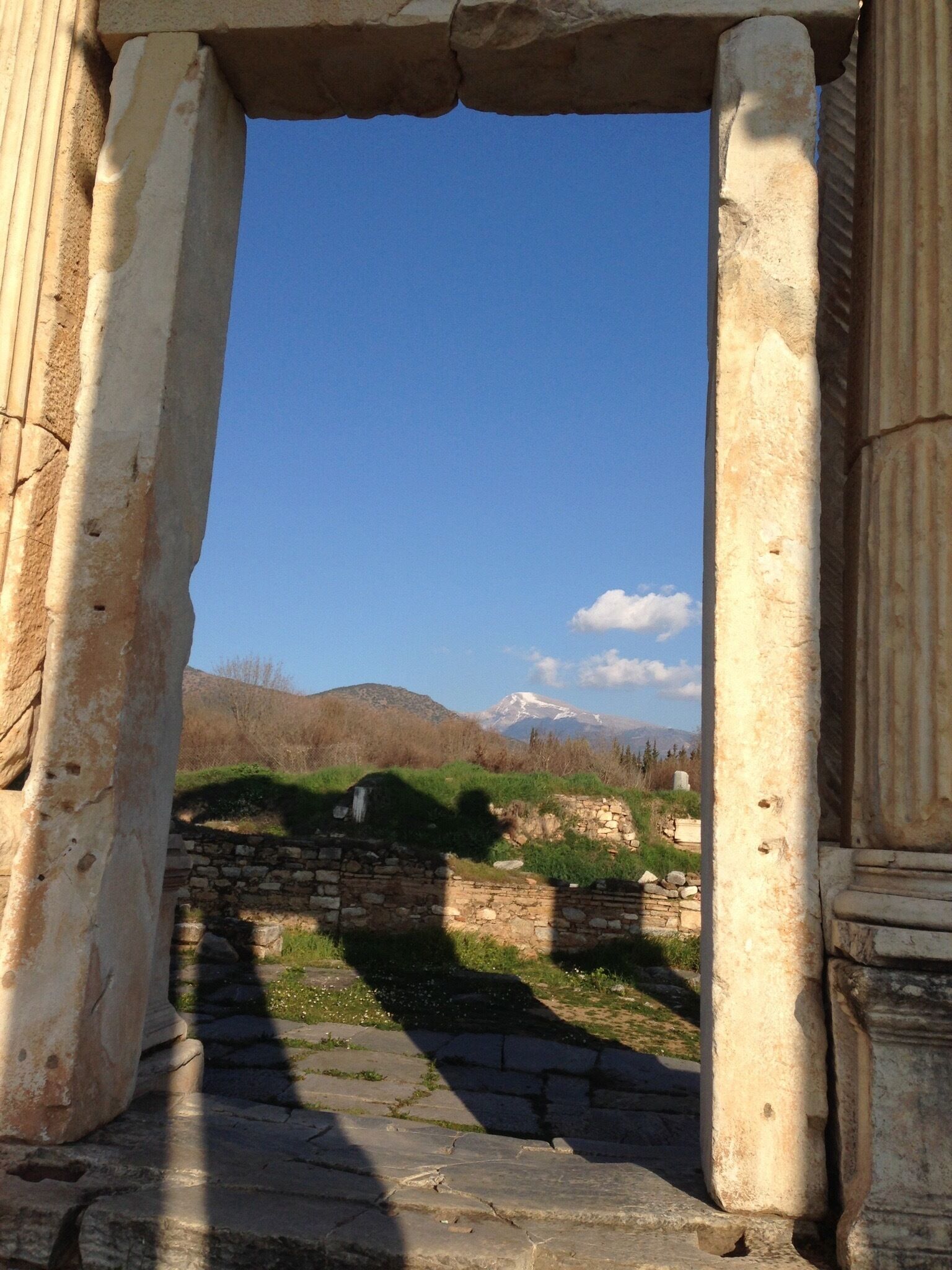 An ancient stone archway leading to a mountainous landscape.