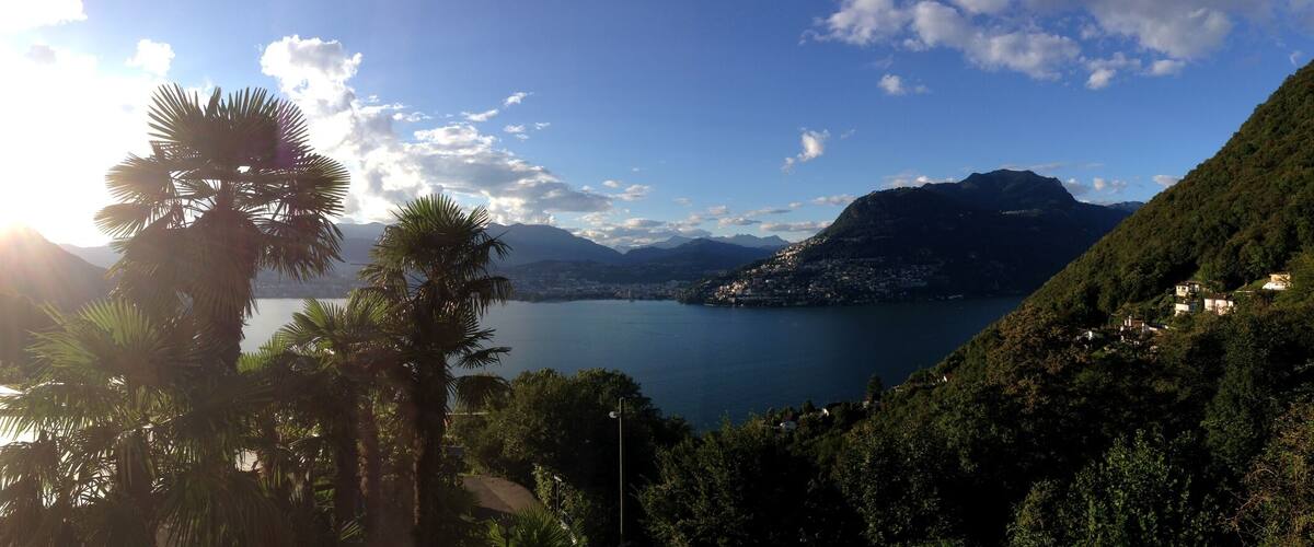 A balcony overlooking a lake with mountains in the background.