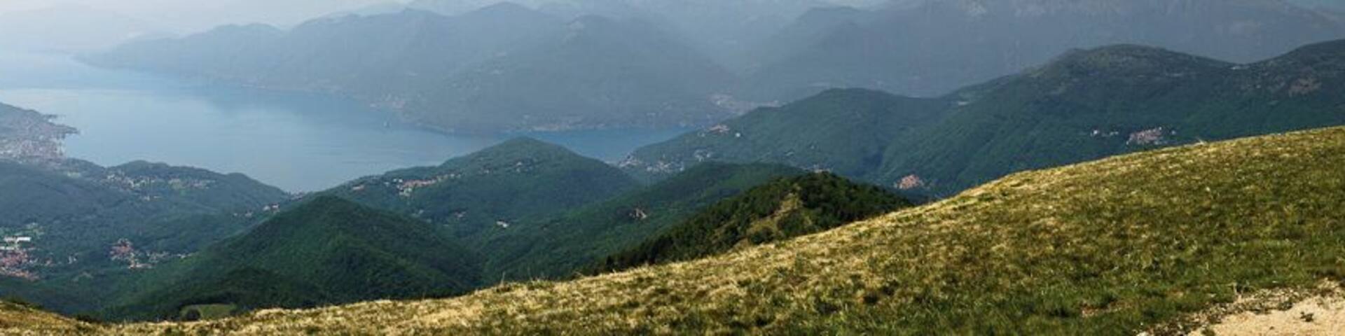 Blick vom Gipfel des Monte Lema in Richtung Lago Maggiore, Luino, Brissago. Rechter Hand unter den Wolken ist die Alpenkette mit dem Monte Rosa zu erkennen. Das Panorama wurde aus neun einzelnen Hochkant Aufnahmen erstellt. View from the top of Monte Lema to the Lago Maggiore with the town Luino and the Brissago Islands. The Alps, with the Monte Rosa, can be found In the upper right hand corner below the clouds. The panorama image was built from nine single pictures. Foto Peter Sieling twitter: @Bluespete