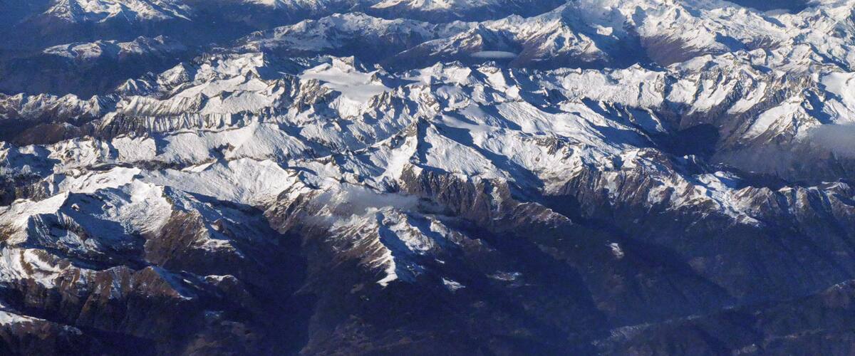 A range of snow-covered mountains with rugged terrain and valleys.