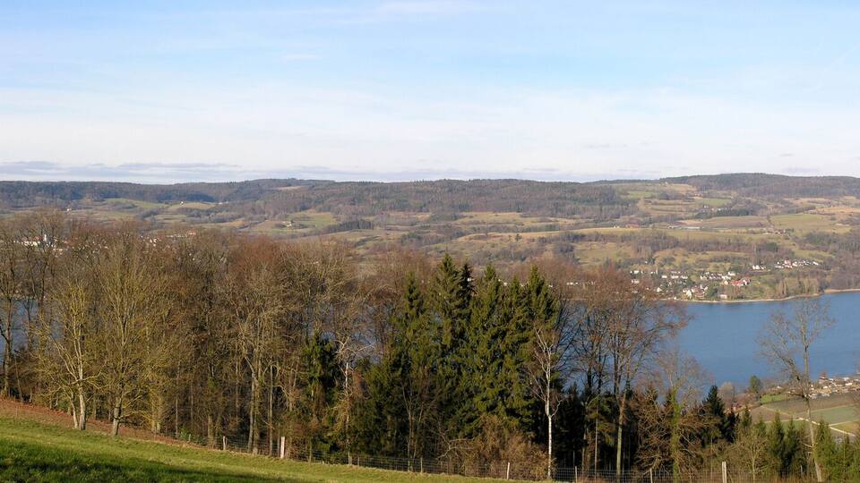 A lake surrounded by hills and trees.