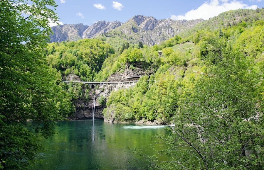 Ein Fluss mit einer Brücke und einem Wasserfall.