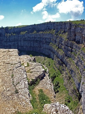 Un vaste canyon calcaire aux parois abruptes, traversé par une rivière.