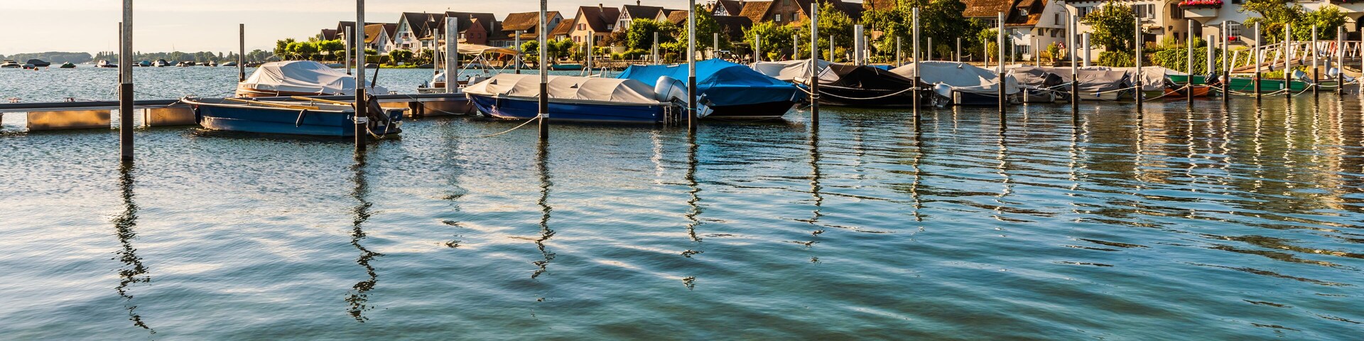 A calm harbor with boats docked, surrounded by traditional houses.