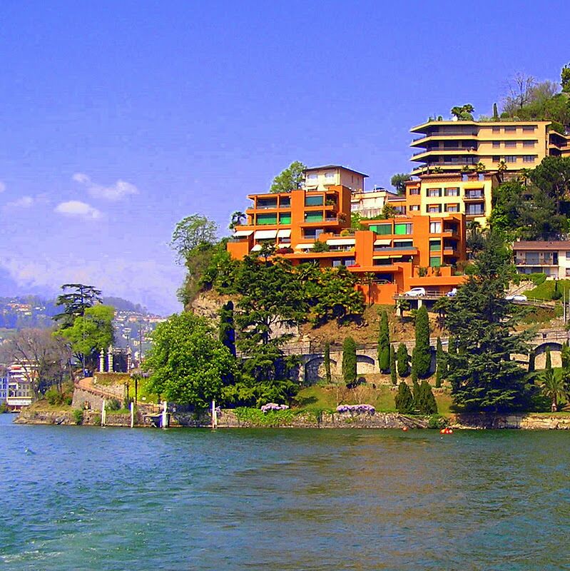 A coastal town with colorful buildings, a clear blue sky, and a calm body of water.