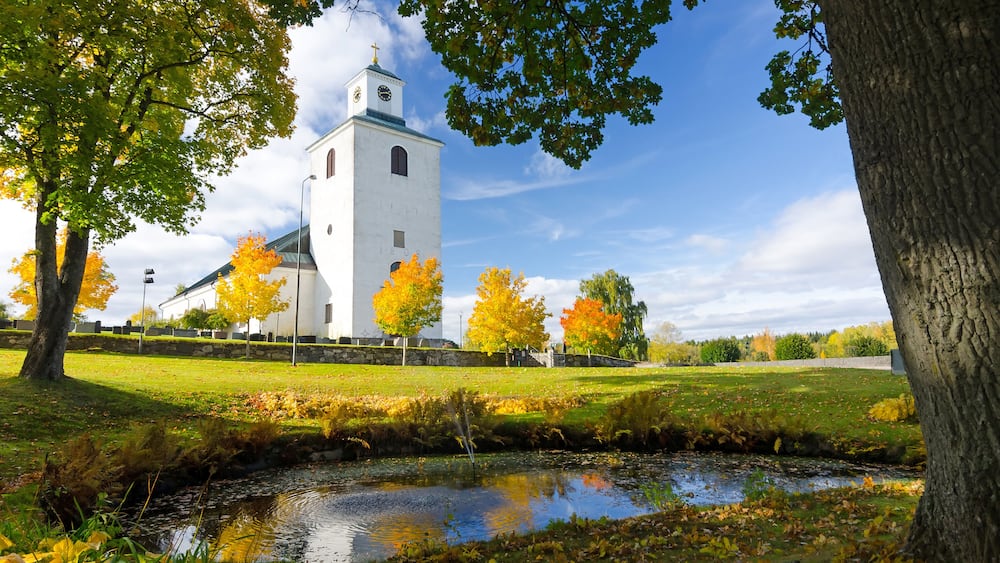 Swedish church with water reflection in autumn season