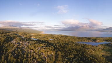 A mountainous landscape with a lake and forested areas.