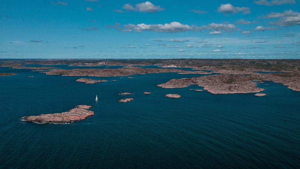 Coast at Mollösund on the archipelago island of Orust on the west coast of Sweden from above, sunshine on the day with a blue sky.