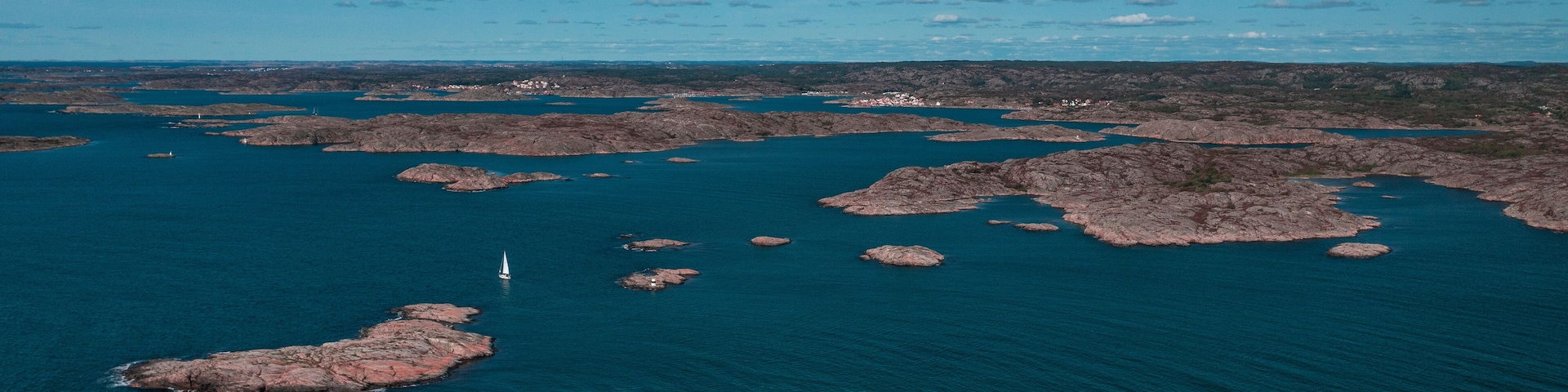 Coast at Mollösund on the archipelago island of Orust on the west coast of Sweden from above, sunshine on the day with a blue sky.