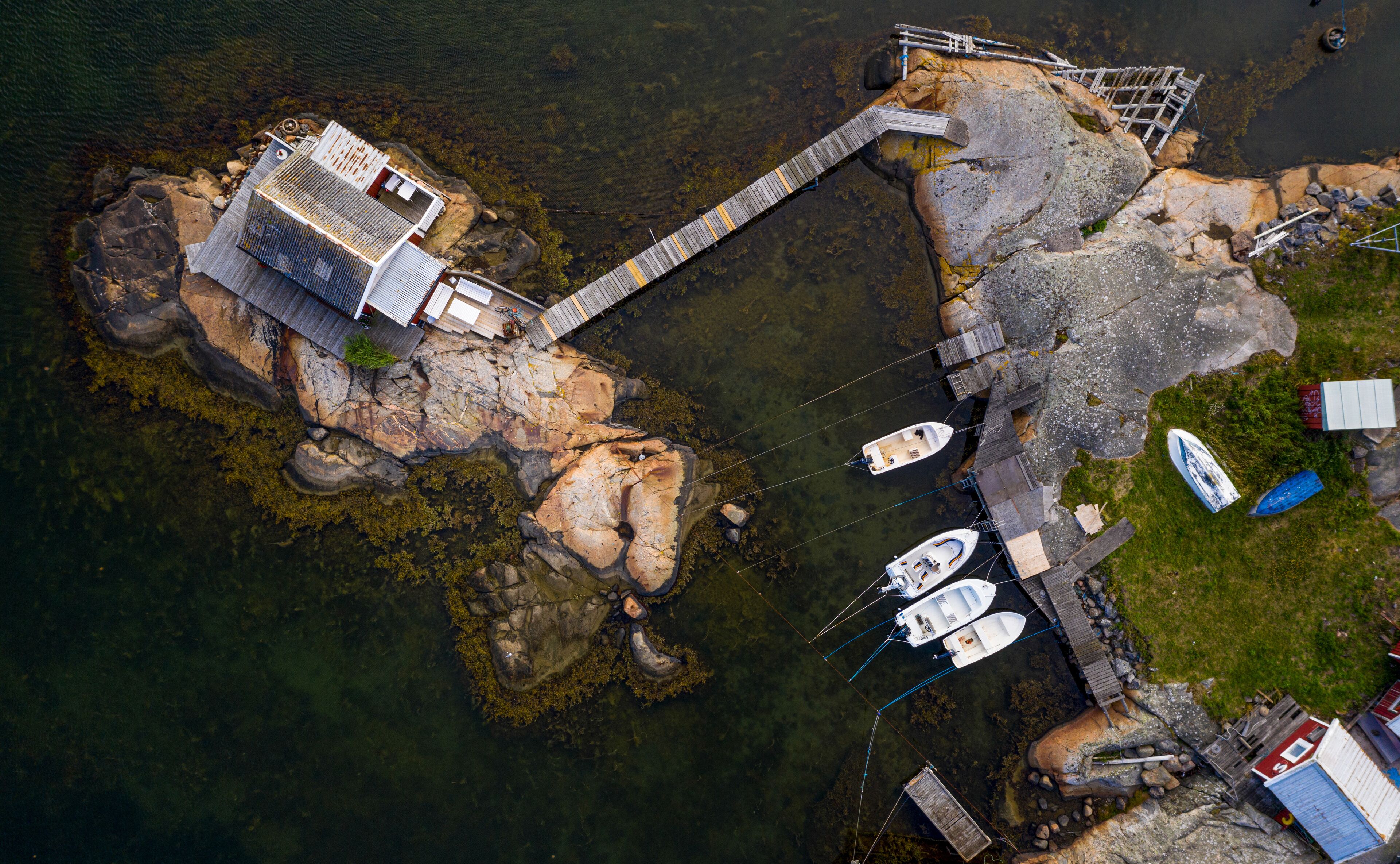 Aerial view of a cottage built on rocks and anchored boats, Hönö, Gothenburg archipelago, Sweden.