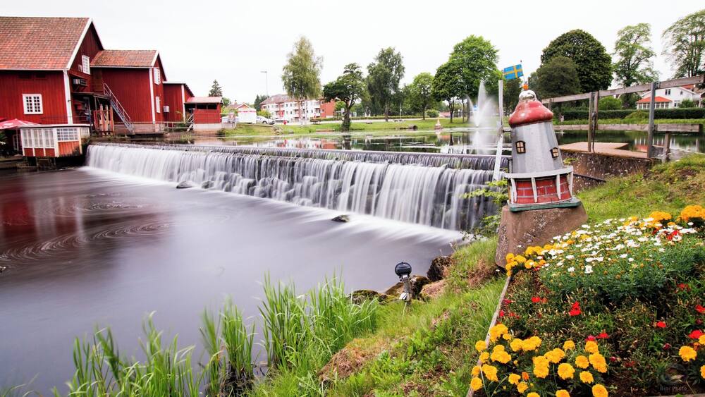 Une cascade, un bâtiment rouge et un phare.