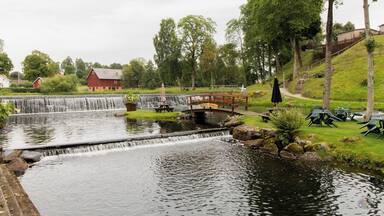A waterfall, picnic tables, and a red barn.