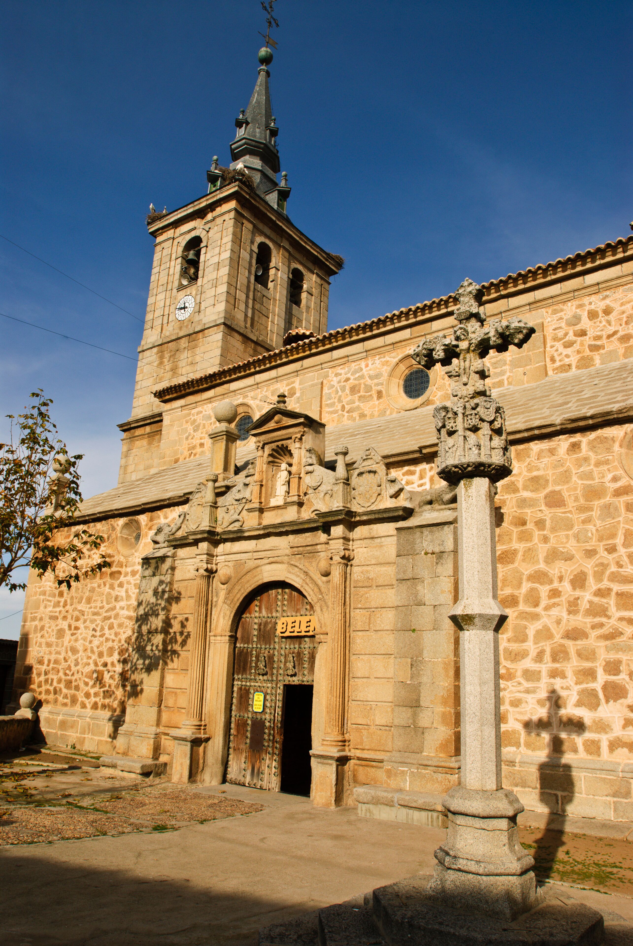 A historic church with a bell tower, ornate facade, and a large wooden door.