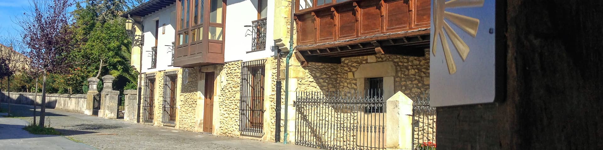 Street of Unquera town with Camino de Santiago sign with scallop and yellow arrow