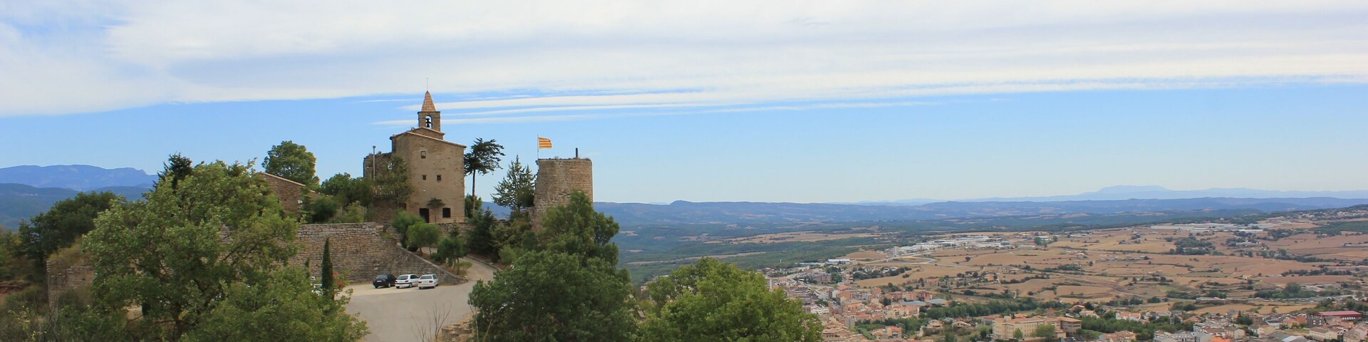 A historic castle on a hill overlooking a town.