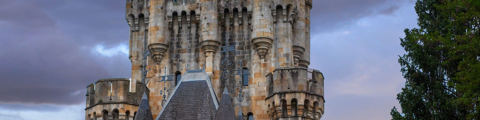 A historic castle with multiple towers and arched windows.