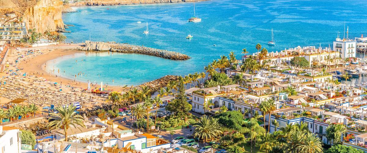 A coastal town with a beach, boats, and buildings.