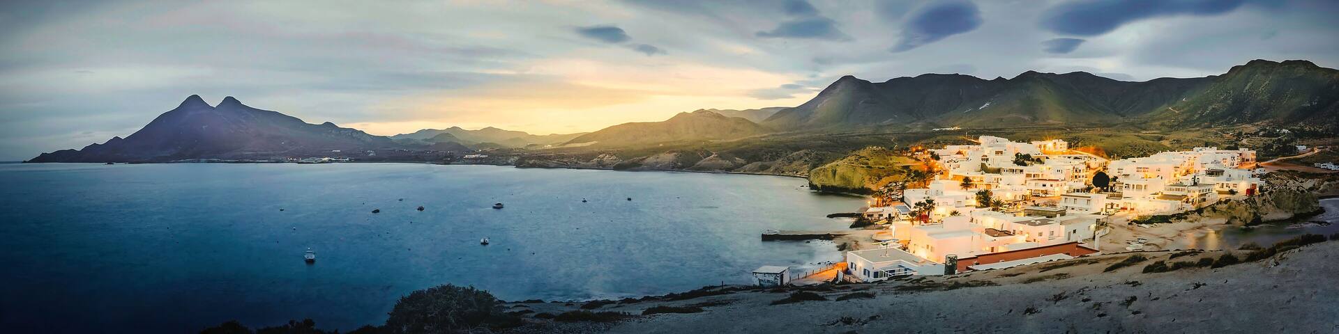 relaxing panoramic view of the sunset over the sea and the quiet village of la isleta del moro in the natural park of cat cape
