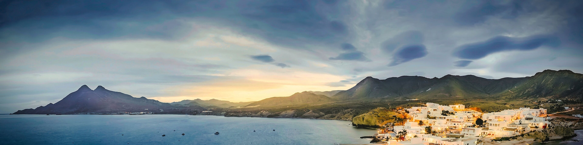 relaxing panoramic view of the sunset over the sea and the quiet village of la isleta del moro in the natural park of cat cape