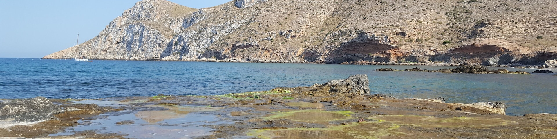 Vista de Cabo Cope desde la Playa de Cope en la cual se pueden observar los distintos acantilados que hacen de esa playa una zona escarpada y rocosa.