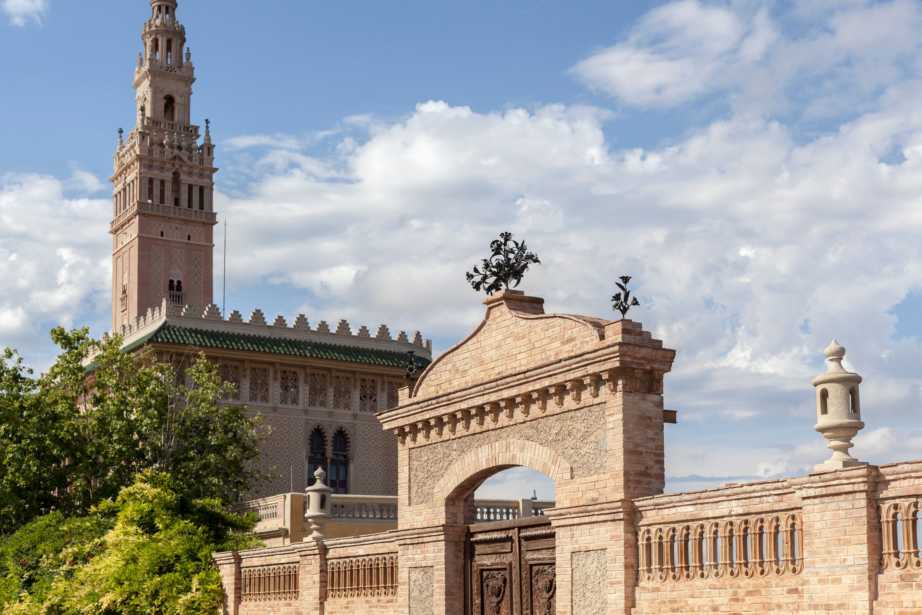 Un edifici històric amb una torre destacada, un arc ornamentat i una espiga decorativa.