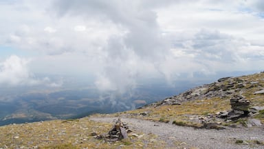 A mountainous landscape with a rocky path and a cairn.