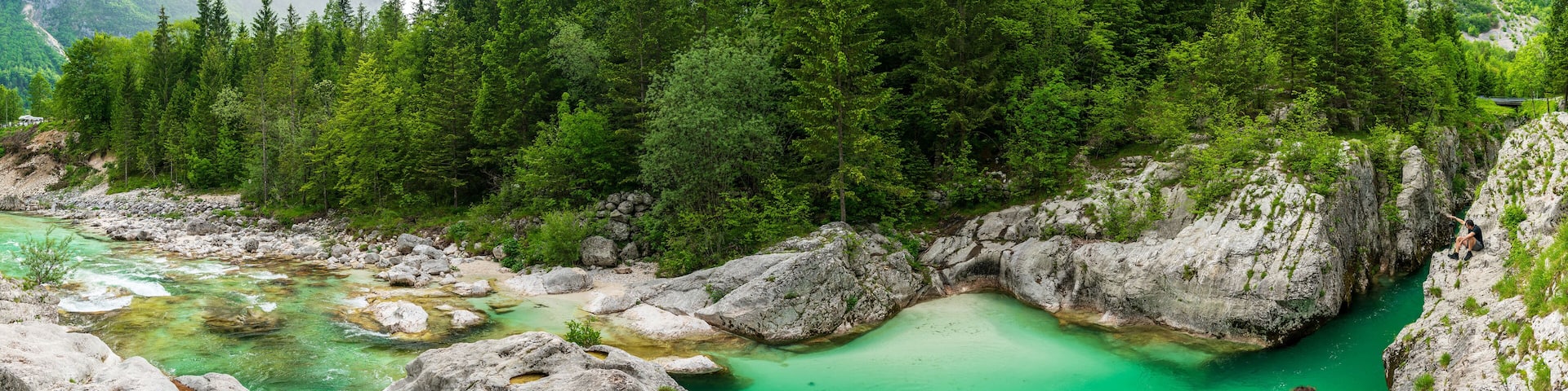 A turquoise river flowing through a rocky gorge surrounded by dense forest.