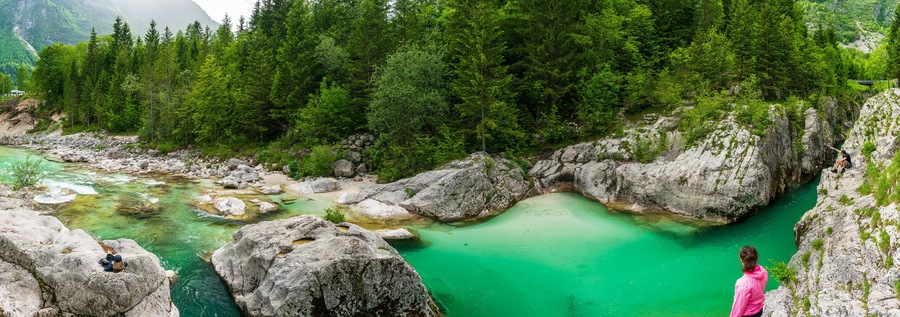 A turquoise river flowing through a rocky gorge surrounded by dense forest.