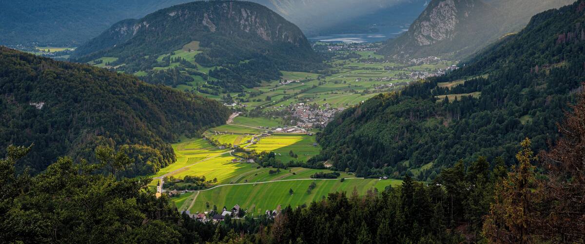 A valley with mountains, fields, and a small town.