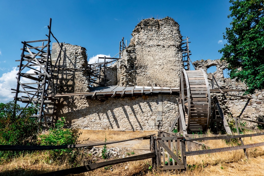 Edifici de pedra històric amb bastiments de fusta i una escala de fusta.