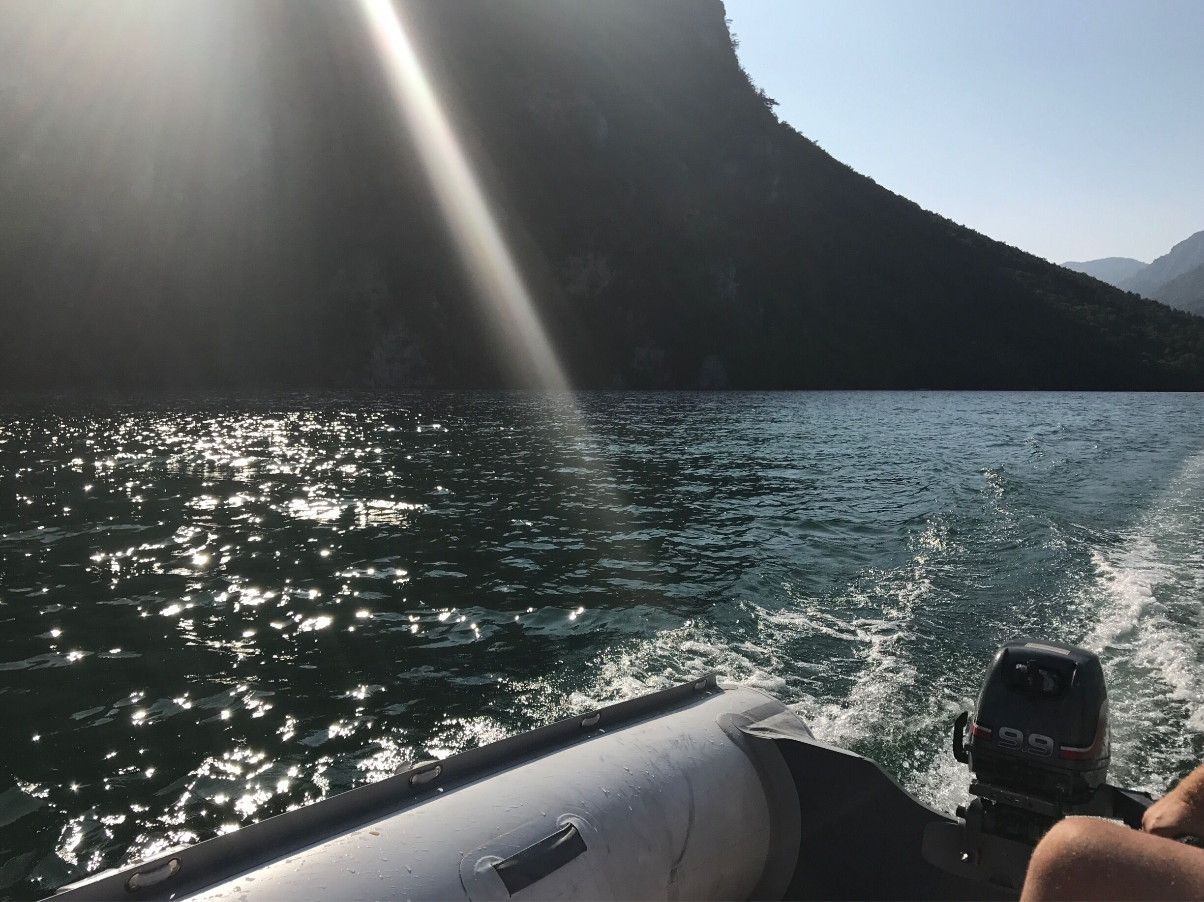 A boat on a lake with a mountain in the background.