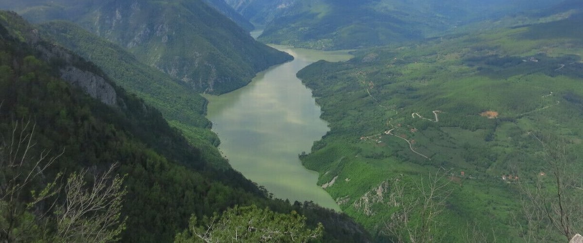 View over the canyon of the Drina river from Banjska Stena viewpoint, in the national park of mountain Tara.
A footpath leads you here from Mitrovac, a tiny village in Western Serbia that has a few hotel facilities and can be reached only by private transport. The following places can be visited nearby:
- Baijna Basta: a small village near Drina with a river house become famous thanks to a beautiful picture on National Geographic.
- Perucac lake: an artificial lake in the middle of Drina which hosts a regatta in July.
- Mokra Gora, with the Šargan 8 railway and Drvengrad, an ethno village built by Kusturica for one of his movies.
#NationalPark