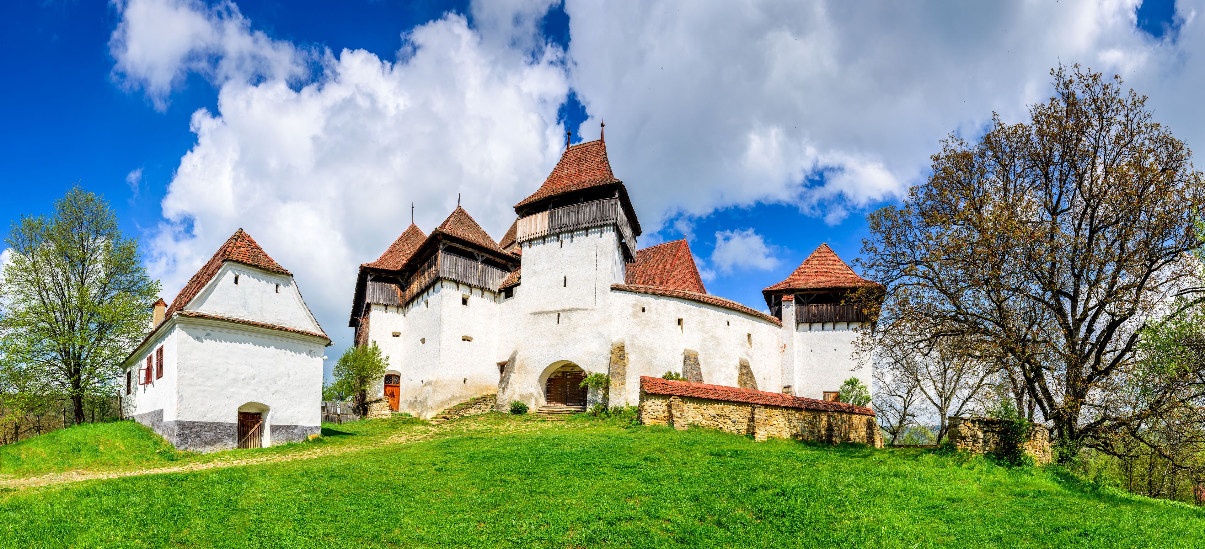 A historic castle with multiple towers and a white facade.