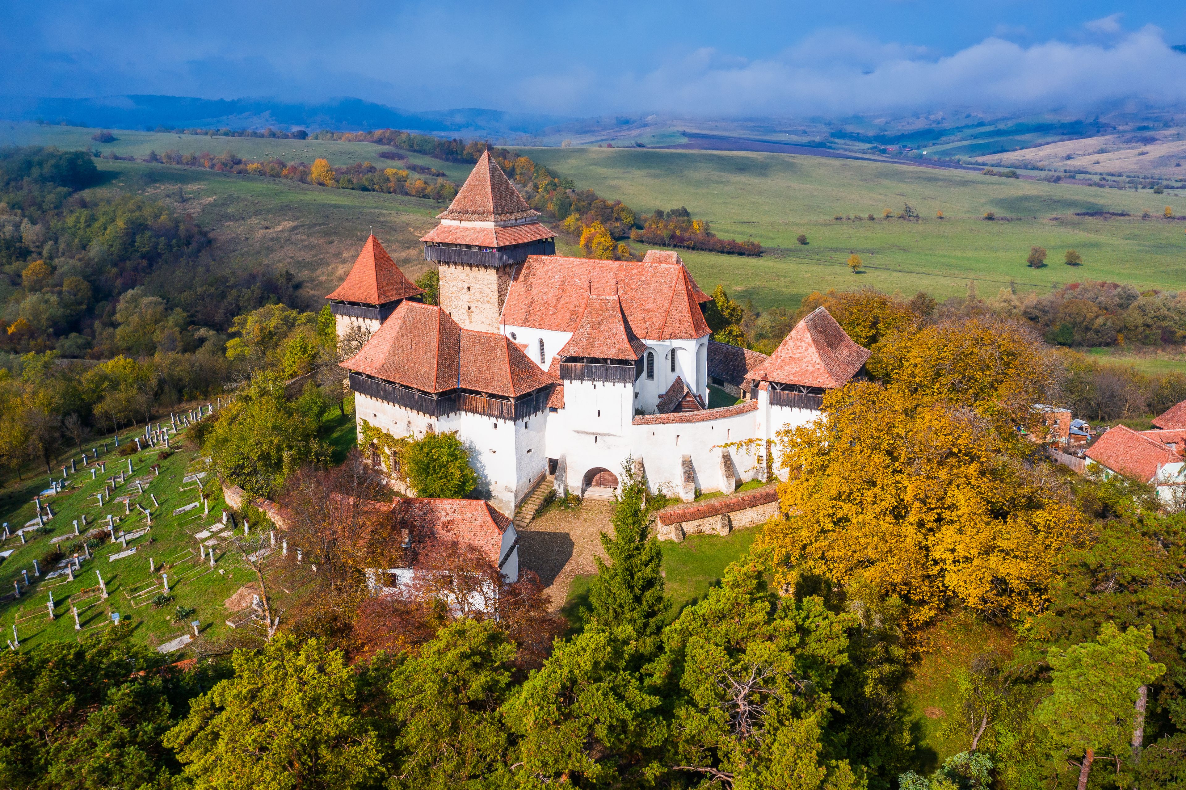 A castle with multiple towers and a surrounding cemetery.