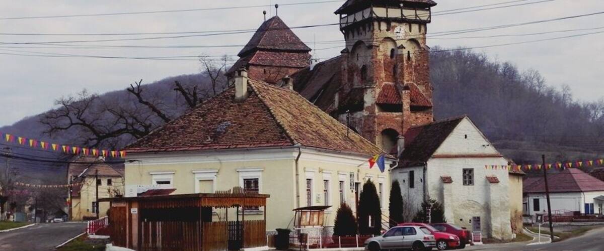 A historic church with a bell tower and a small adjacent building.
