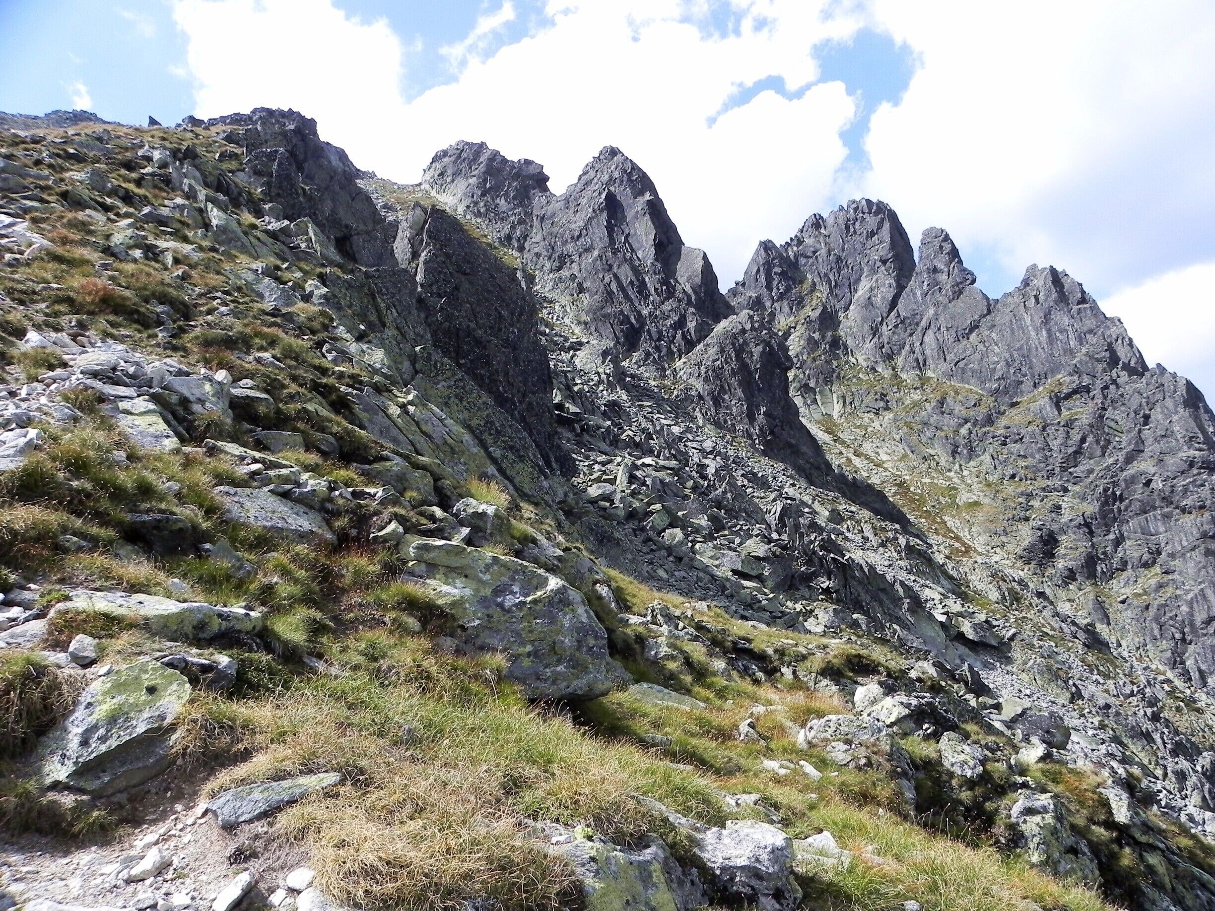 A rugged mountain landscape with rocky terrain and sparse grass.