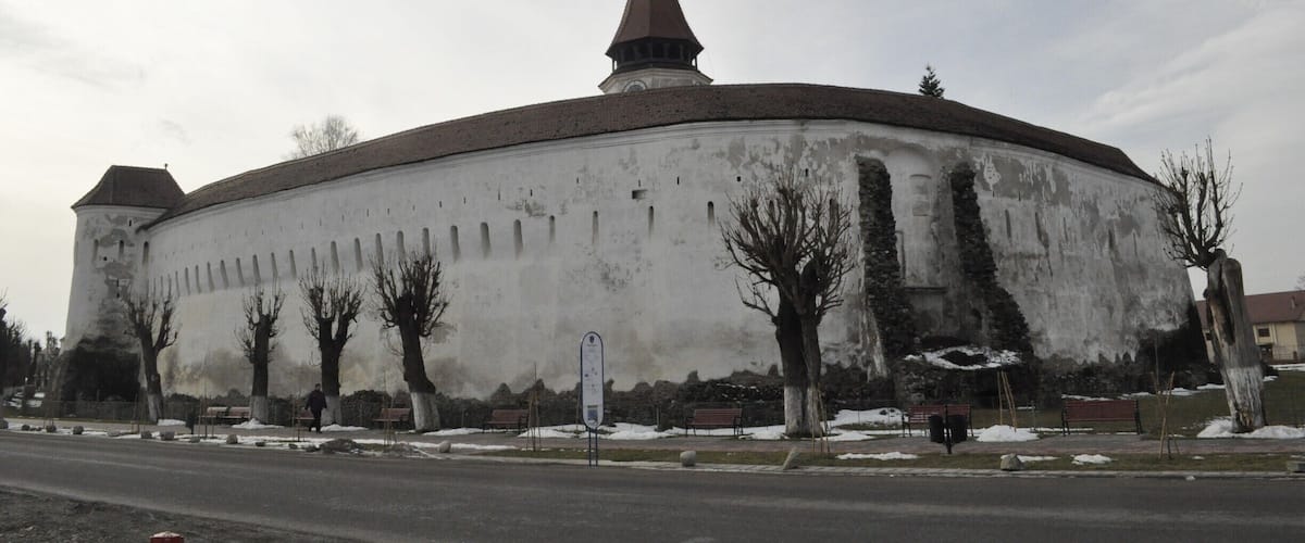 A large, historic building with a prominent tower and a round shape.