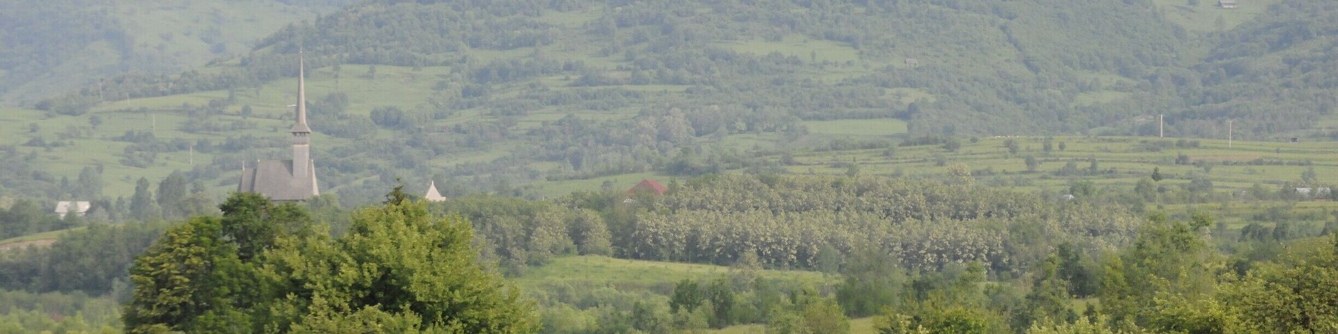 View from Biserica de lemn din Ieud Deal, wooden church completed in the seventeenth century.
"We came to understand that the locals’ zest for life and love for nature are fuelled by a strong connection to the spiritual world. Spirituality is of utmost importance to the people of Maramureş and the many wooden churches situated all over this region stand as evidence to this end. There are many special churches and they are all beautiful in their own way, but the one in Ieud is exquisite. We arrived on a calm summer’s evening and we were greeted by the smell of handmade soap and by the smiles on the villagers’ faces. The hill on which the church stands has in itself a feel of ‘solemn’, which turns into humbleness before the impressive frescoes. We decided to climb the old and squeaky wooden stairs leading to the church’s tower and the view revealed the surrounding hills framing the village – a small Eden, undisturbed and dateless! This place breathes history through all of its pores, as we were standing in the exact spot where the first document written in Romanian – ‘The Ieud Codex’ (1391) – was found. I
wondered - doesn’t this add a feel of ‘majesty’ to it all?"