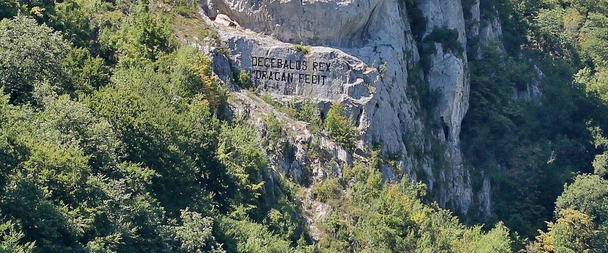 A rock face with a carved face and the inscription "DECEBALUS REX DRAGAN FECIT".