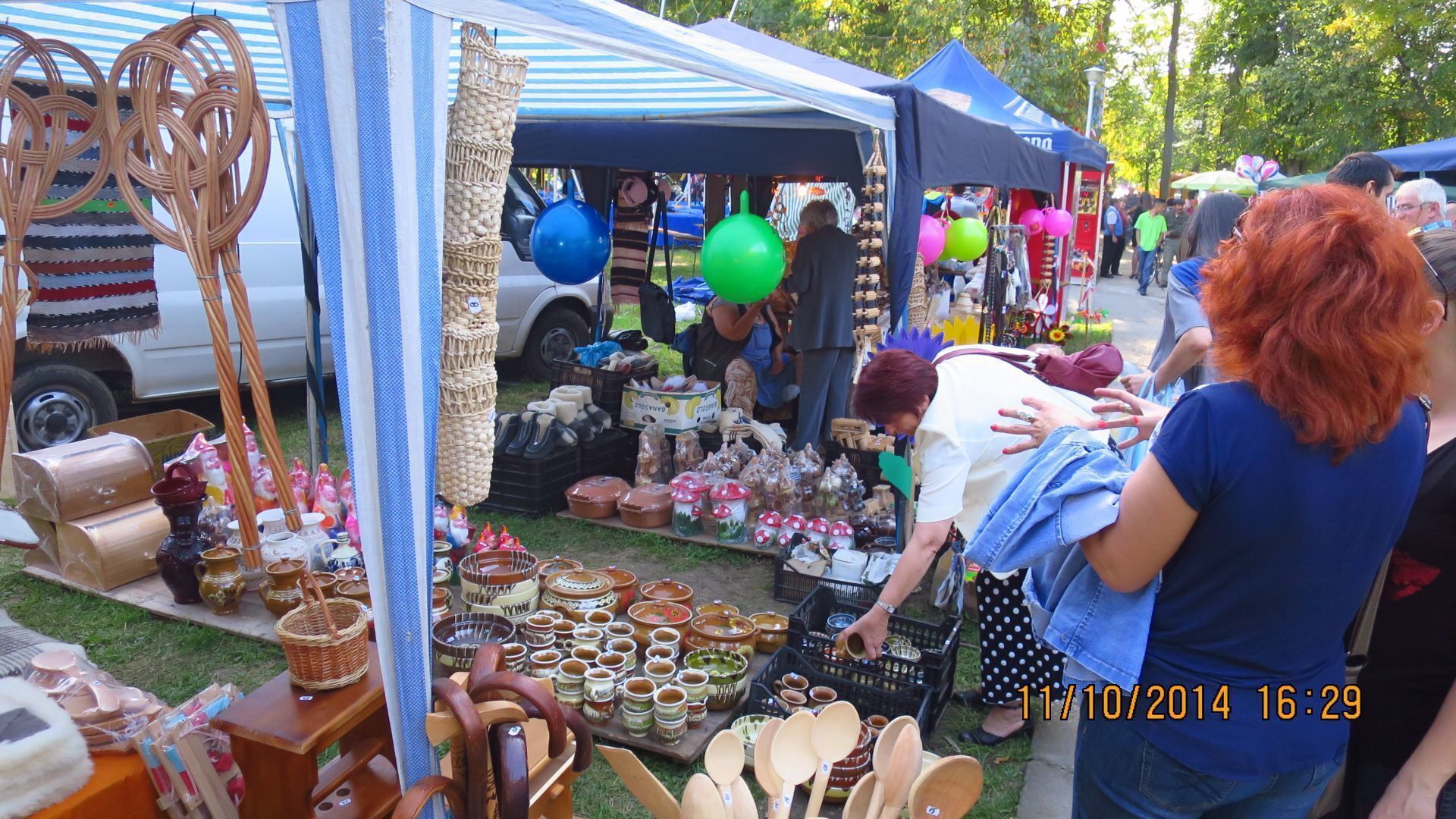 A market stall with various pottery items and wooden utensils.