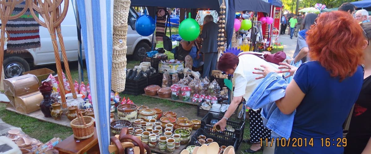 A market stall with various pottery items and wooden utensils.