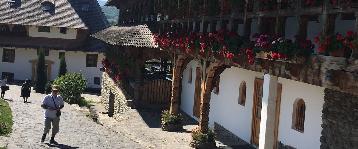 A cobblestone street lined with traditional buildings, some with flower boxes and wooden beams.